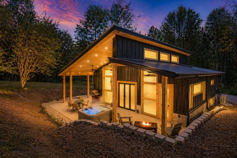 Stone and Cedar Escape, a modern cabin lit up at dusk
